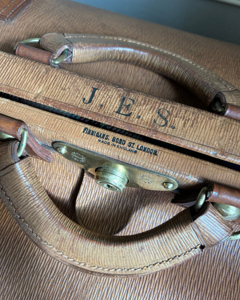 Vintage suitcase with 'J.E.S.' branding and 'Made in England' text.