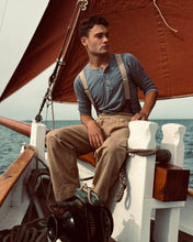 Man on a wooden sailing boat in a t-shirt