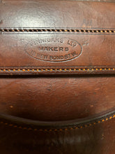 Close-up of a brown leather product with stitching details and a visible brand logo.