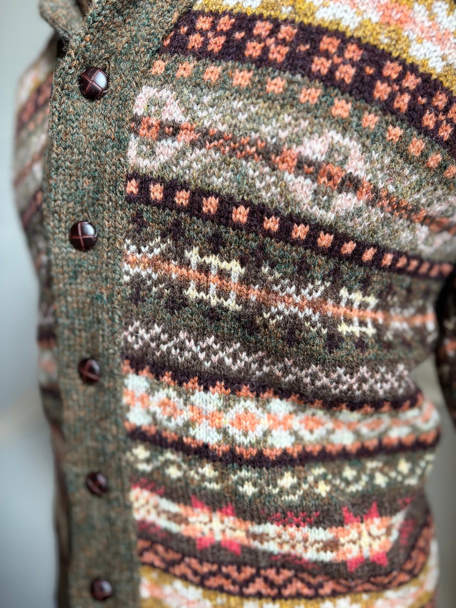 Close-up of a patterned sweater with buttons on a blurred background