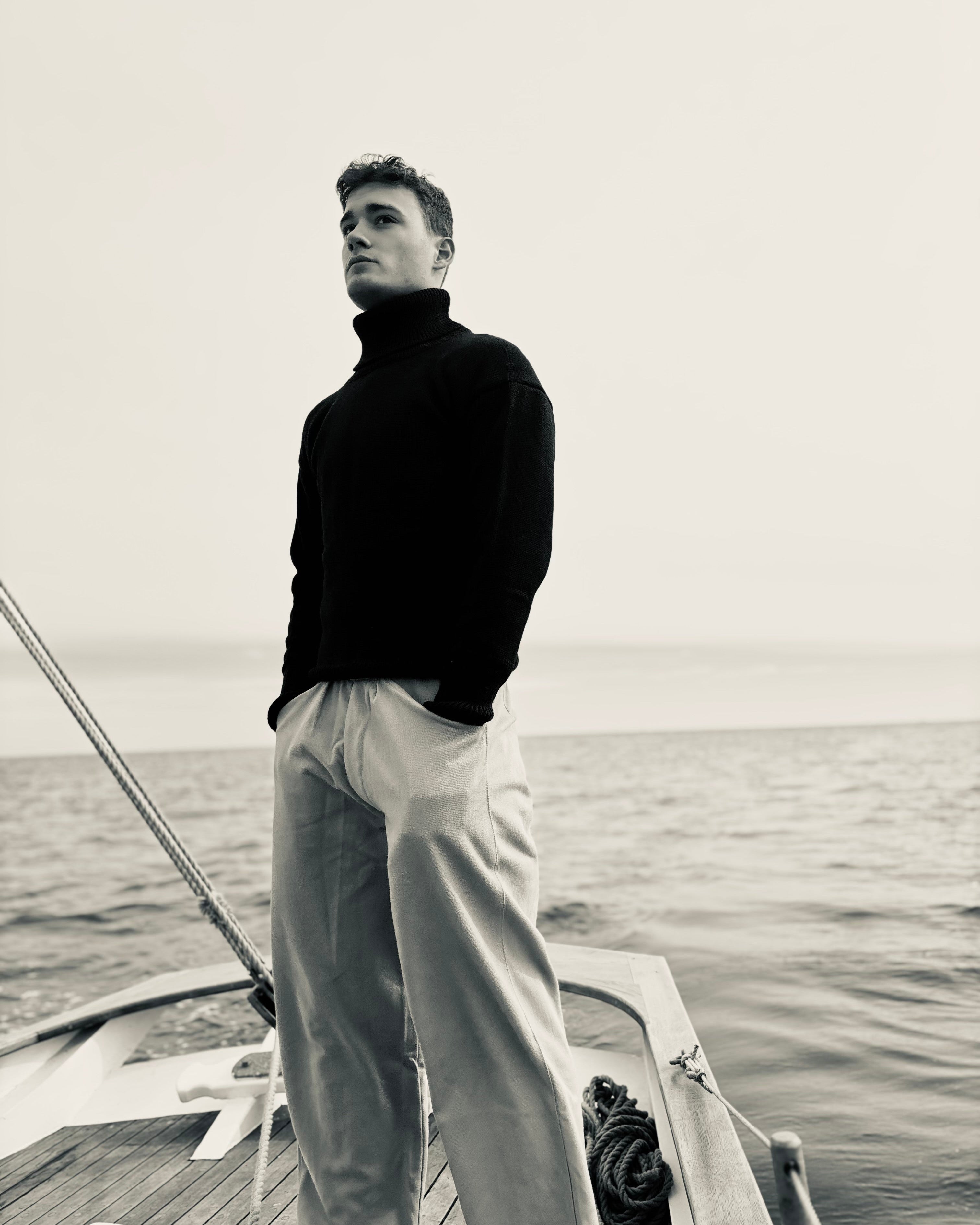 Man standing on a boat with a calm sea background