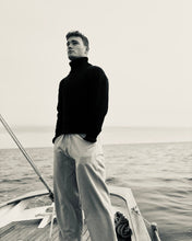 Man standing on a boat with a calm sea background