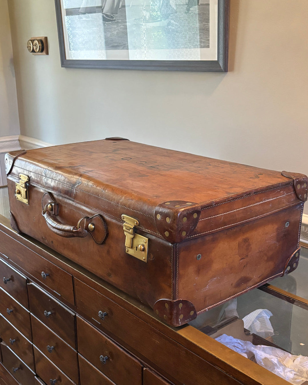 Vintage brown suitcase on a wooden dresser