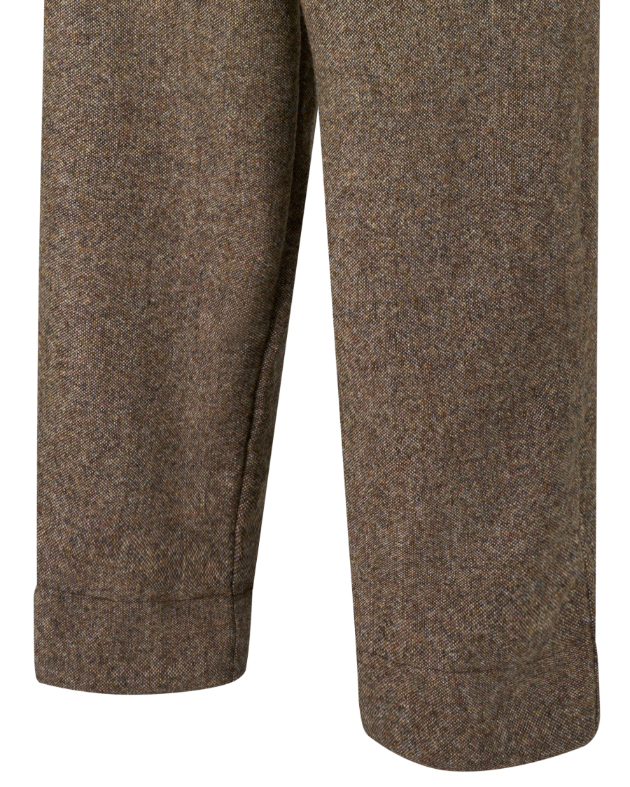 Close-up of the lower legs of brown tweed trousers, showing the fabric texture and cuff details against a plain white background.