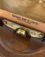 Close-up of a brown leather Gladstone Kit bag handle with 'Made in England' text.