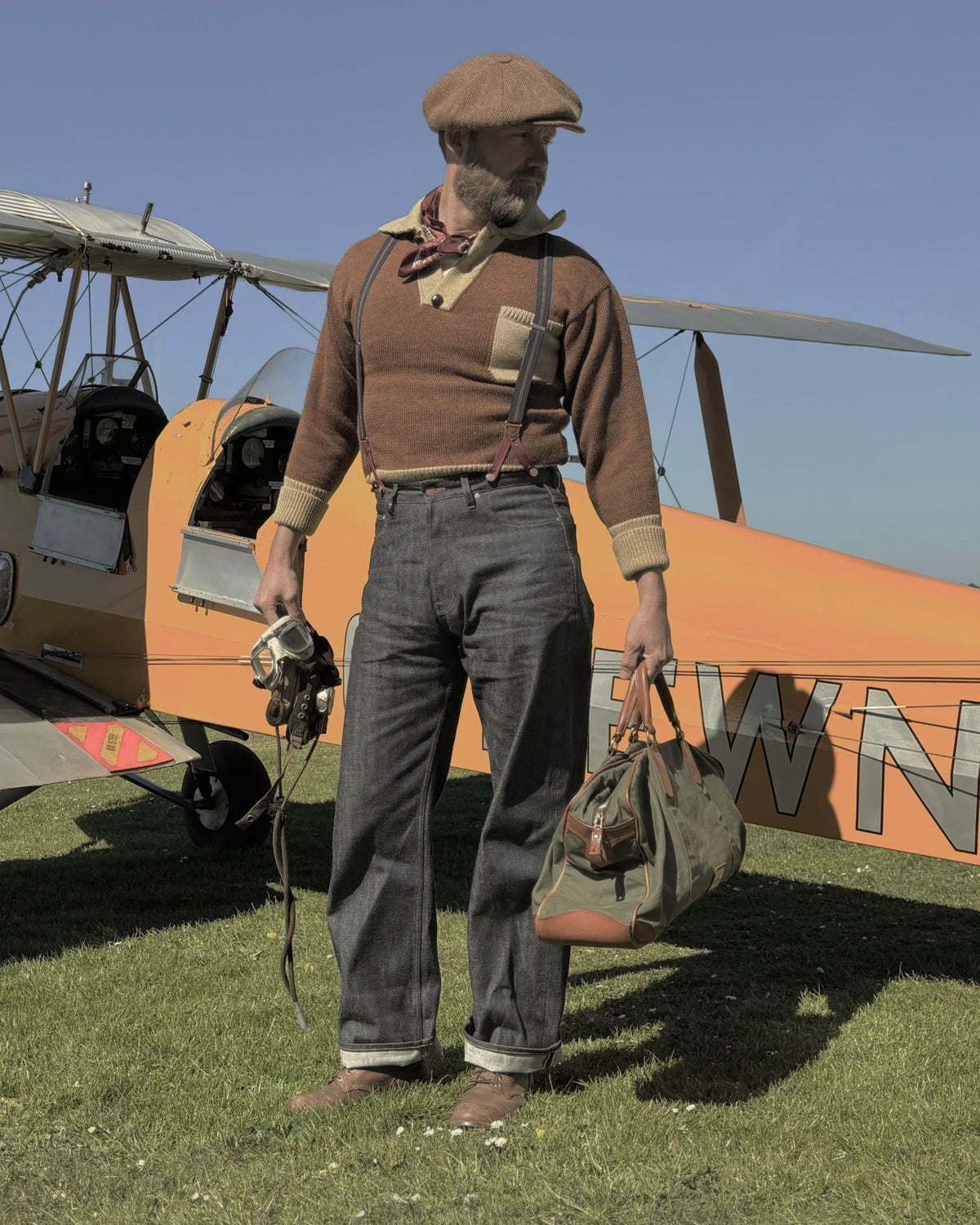 Mens Vintage Japanses Selvedge Raw Denim.  Standing in front of a vintage plane with goggles and a 1940s leather bag.