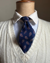 Mannequin wearing a white shirt, blue patterned tie, and light gray sweater.