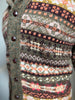 Close-up of a patterned sweater with buttons on a blurred background