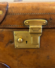 Close-up of a brass latch on a brown leather suitcase