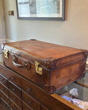 Vintage brown suitcase on a wooden dresser