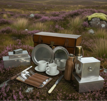 Vintage Picnic setup with plates, cups, and cutlery on a grassy field with purple flowers.