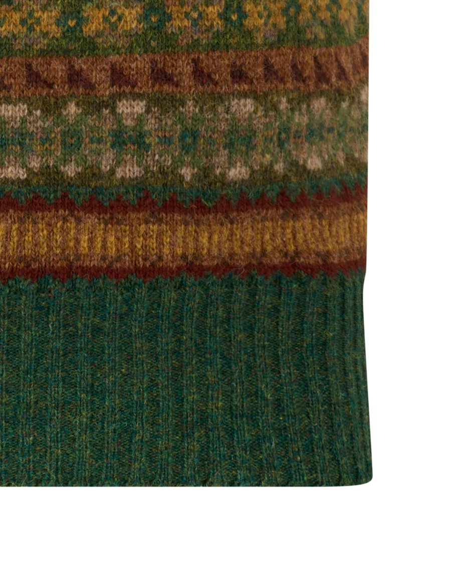 A green V-neck knit sweater vest with a multicolor Fair Isle pattern, featuring horizontal bands of brown, rust orange, and cream geometric motifs, shown against a plain white background.