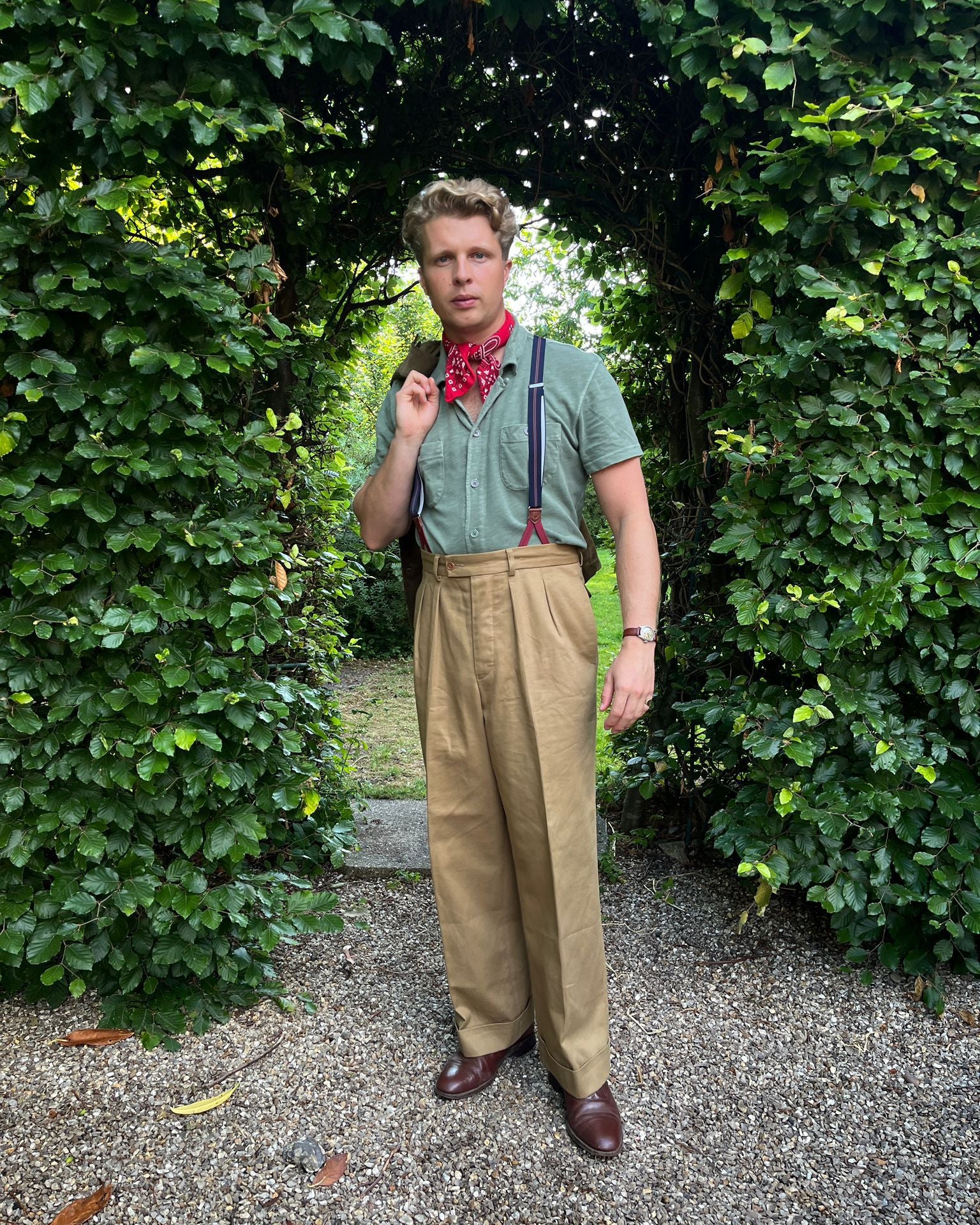 Man in vintage attire standing in a garden setting