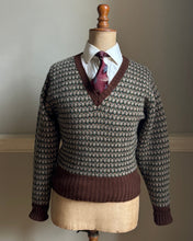 Brown patterned sweater on a mannequin with a white shirt and tie against a neutral background