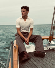 Man sitting on a boat in the middle of the ocean