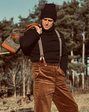 Man wearing 1930s workwear cords, submariner polo neck and leather and canvas bag